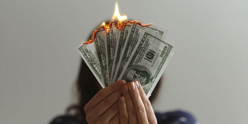 One hundred dollar bills lit on fire