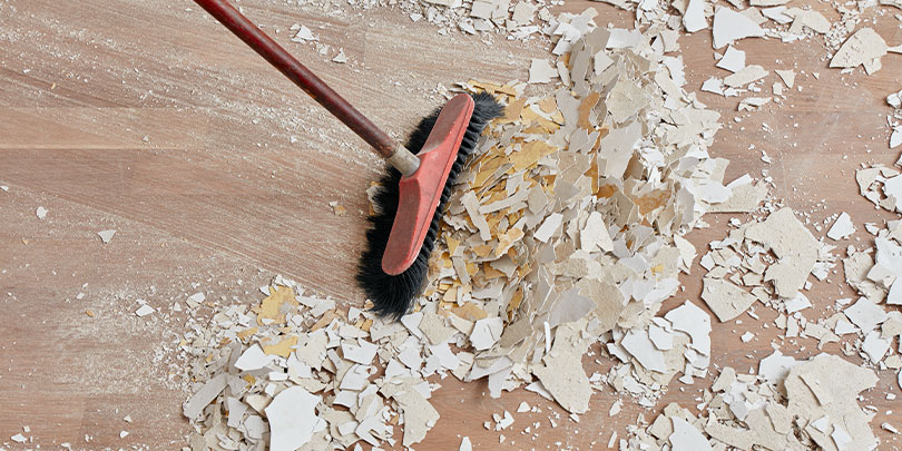 Broom sweeping up construction dust and debris